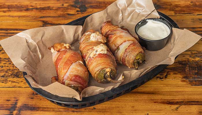 Three bacon-wrapped stuffed jalapeños served with sauce from our BBQ Menu in Mundelein IL.