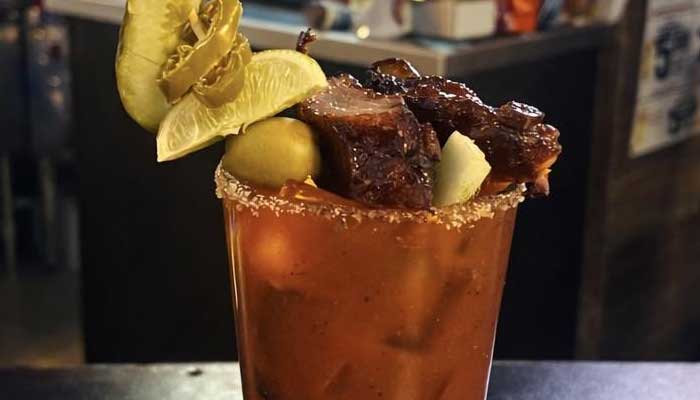 A Bloody Mary with pickles, jalapeños, lime, olives & ribs—classic BBQ food and drinks in Mundelein IL.