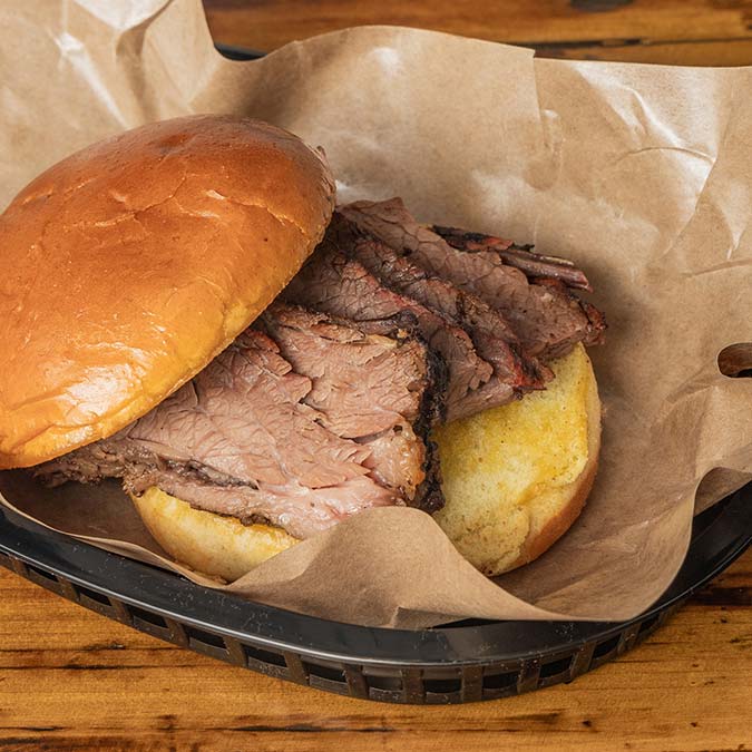 Brisket sandwich with sliced beef on a bun at a top BBQ Restaurant in Mundelein IL.