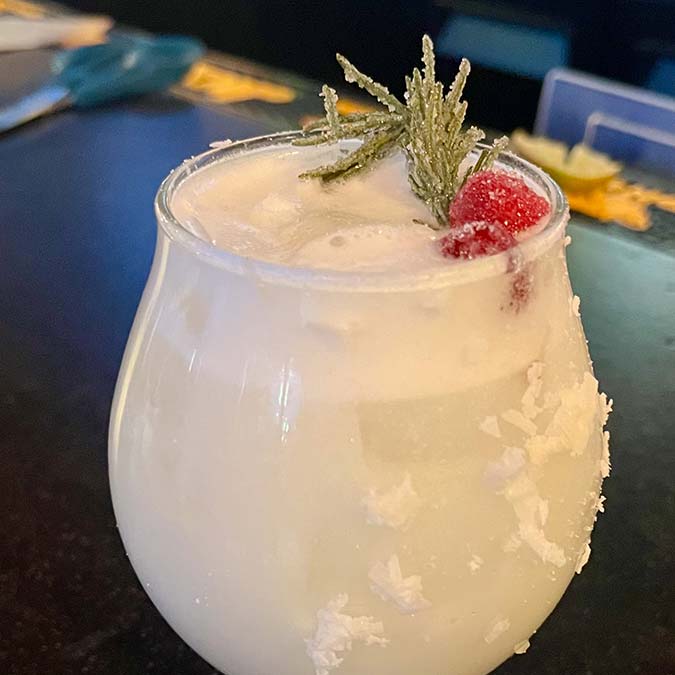 White holiday cocktail with frothy top, garnished at a BBQ Restaurant in Mundelein IL.
