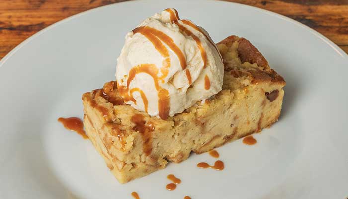 A slice of bread pudding with vanilla ice cream and caramel, featured on our BBQ Menu in Mundelein IL.