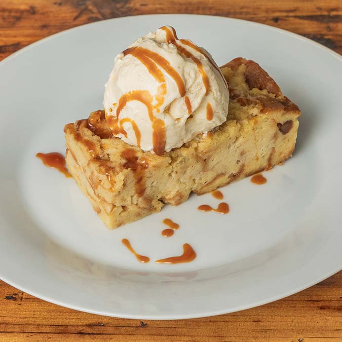 A slice of bread pudding with vanilla ice cream and caramel at a BBQ Restaurant in Mundelein IL.
