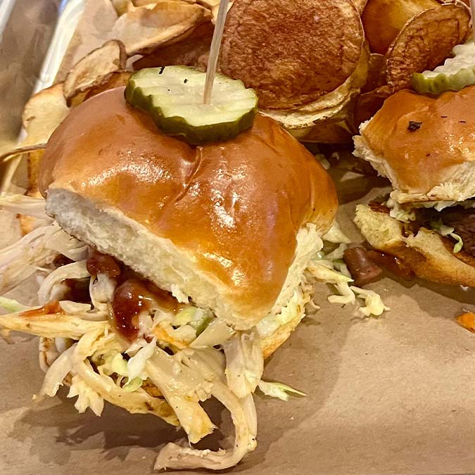 Pulled chicken sandwich with slaw and pickles, served at a top BBQ restaurant in Mundelein IL.